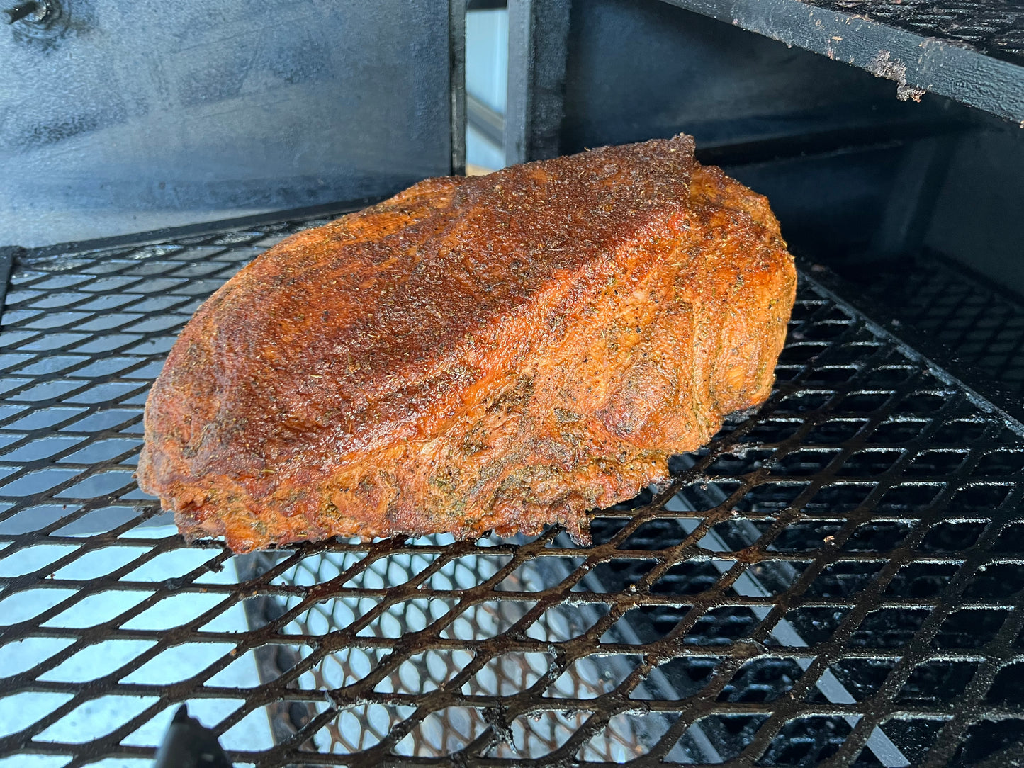 Tender smoked pulled pork servd on buttered texas toast with a side with a side of cole slaw on the side.